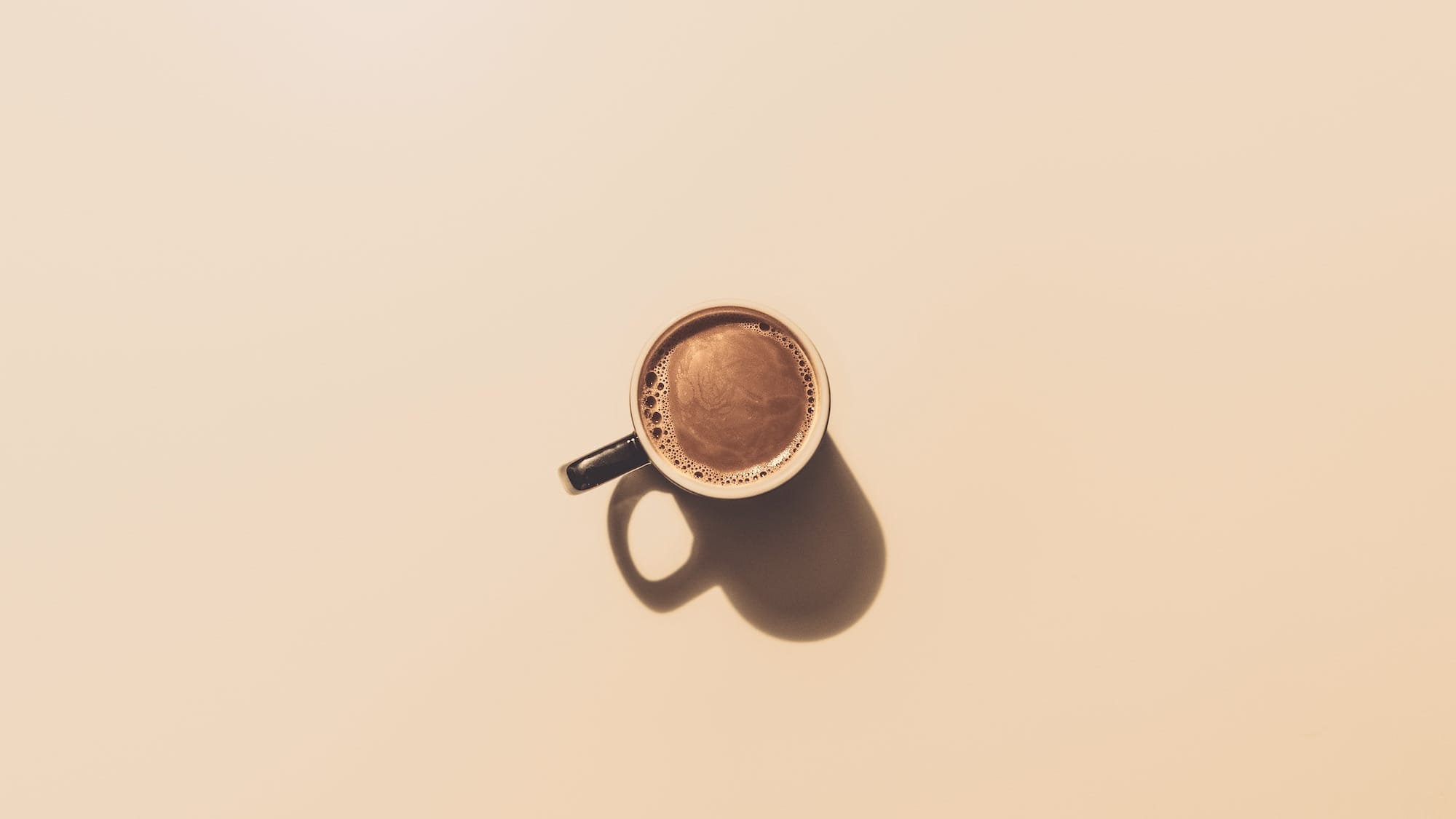 A cup of coffee on a cream background